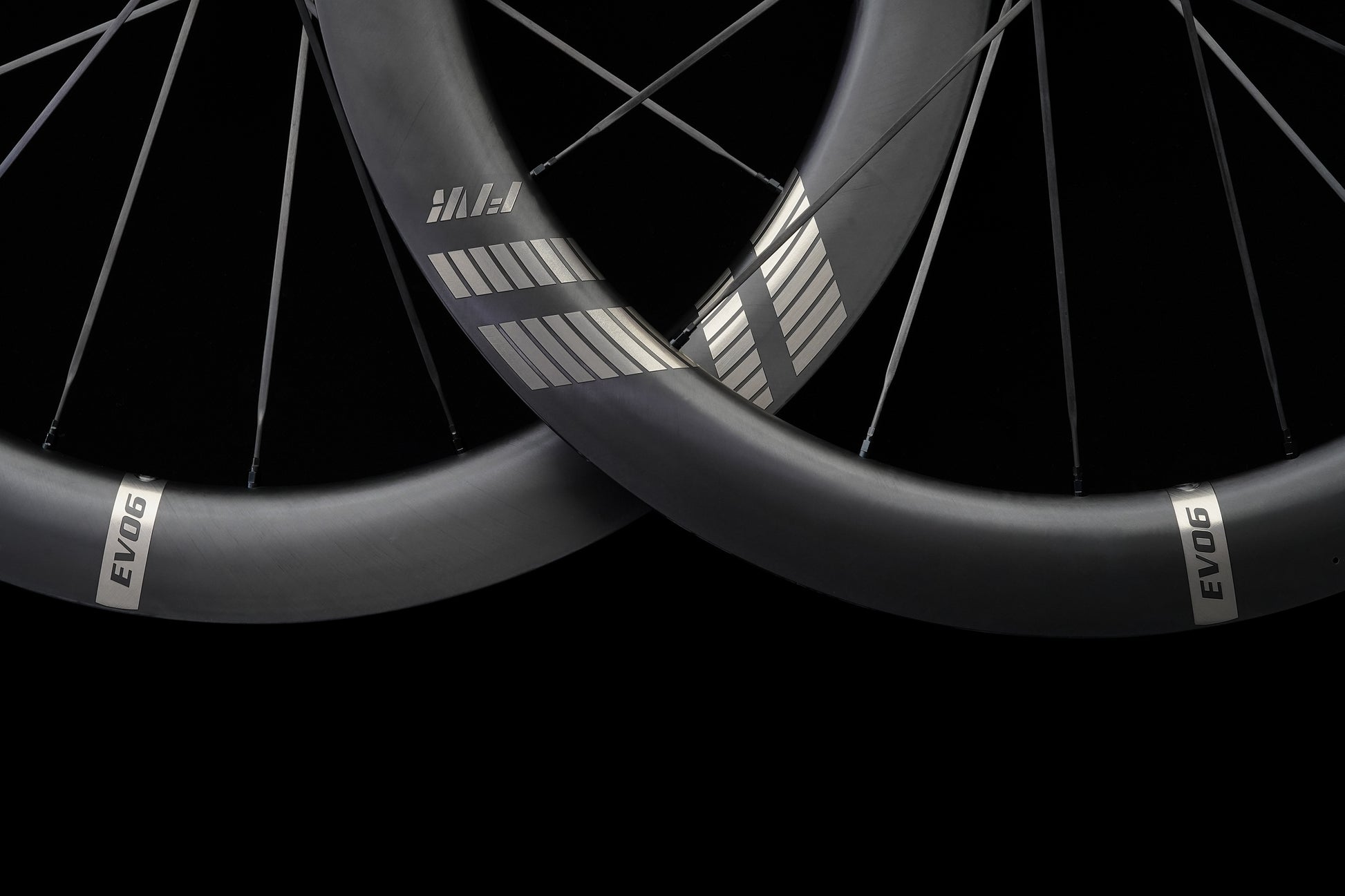 Close-up of two black carbon bicycle wheels with 'EVO' branding on a black background