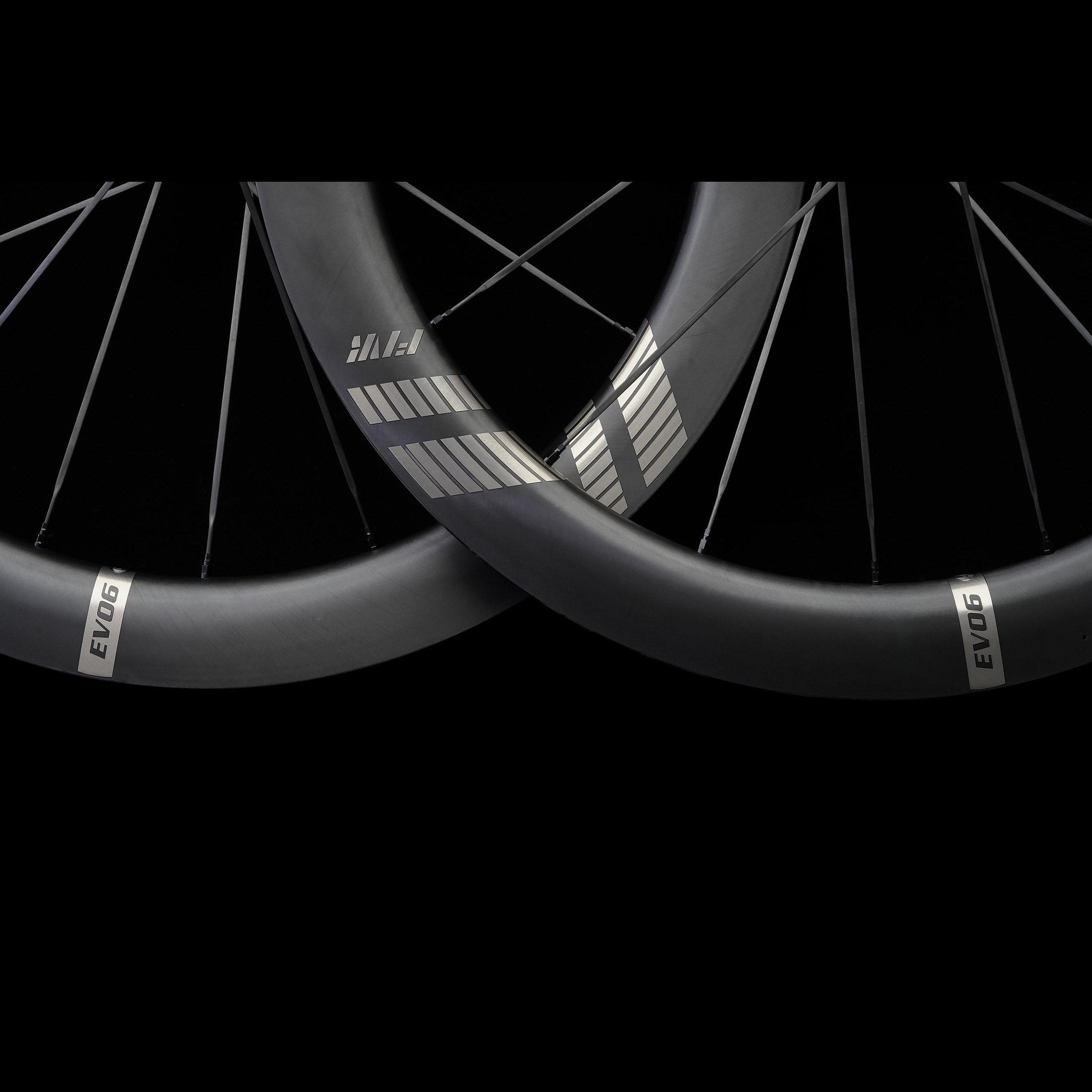 Close-up of two black carbon bicycle wheels with 'EVO' branding on a black background